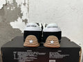Rear view of black Converse sneakers with white heel panels and gum-colored outsoles.