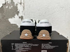 Rear view of black Converse sneakers with white heel panels and gum-colored outsoles.