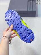 Close view of the sneaker outsole showing a blue textured tread with neon yellow side detailing.