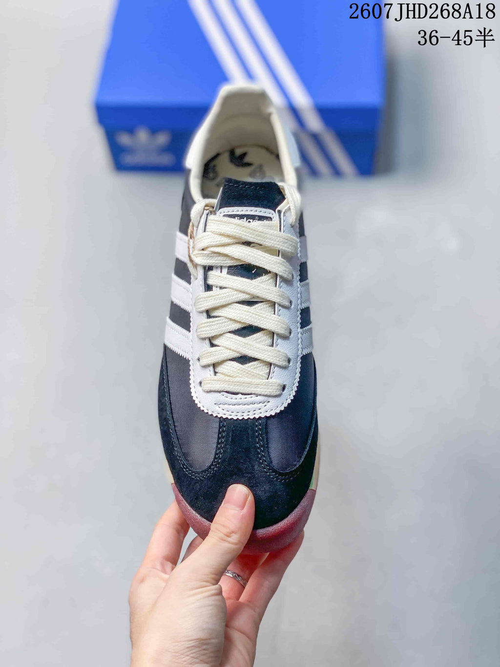 Top view showing the cream laces, white lace surround, dark navy toe panels, and three-stripe details.