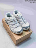 Pair of white and gray Salomon XT-Quest ATHR sneakers on a shoebox.