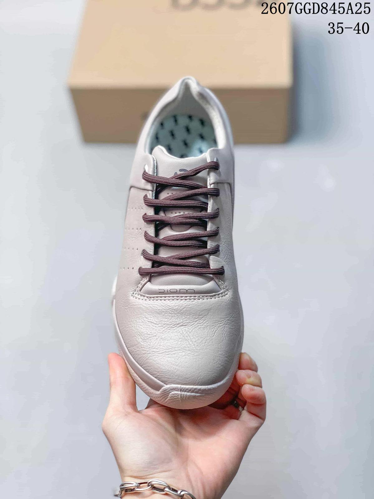 Top view of the white lace-up sneaker showing the rounded toe, dark laces, and patterned insole.