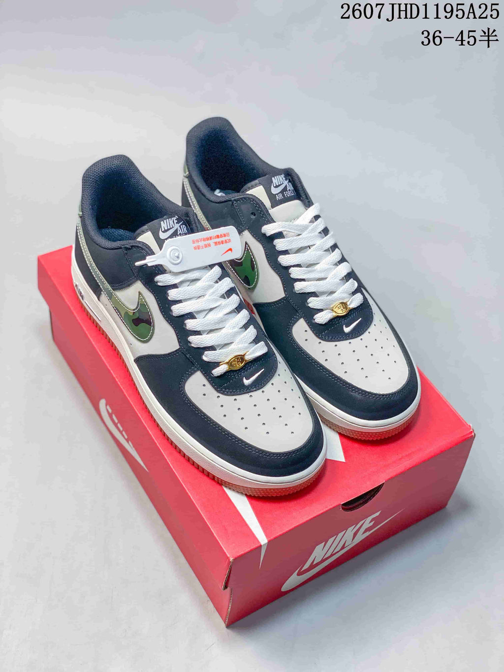 Pair of navy and white low-top sneakers with green camouflage-patterned Swoosh details displayed on a red Nike shoebox.