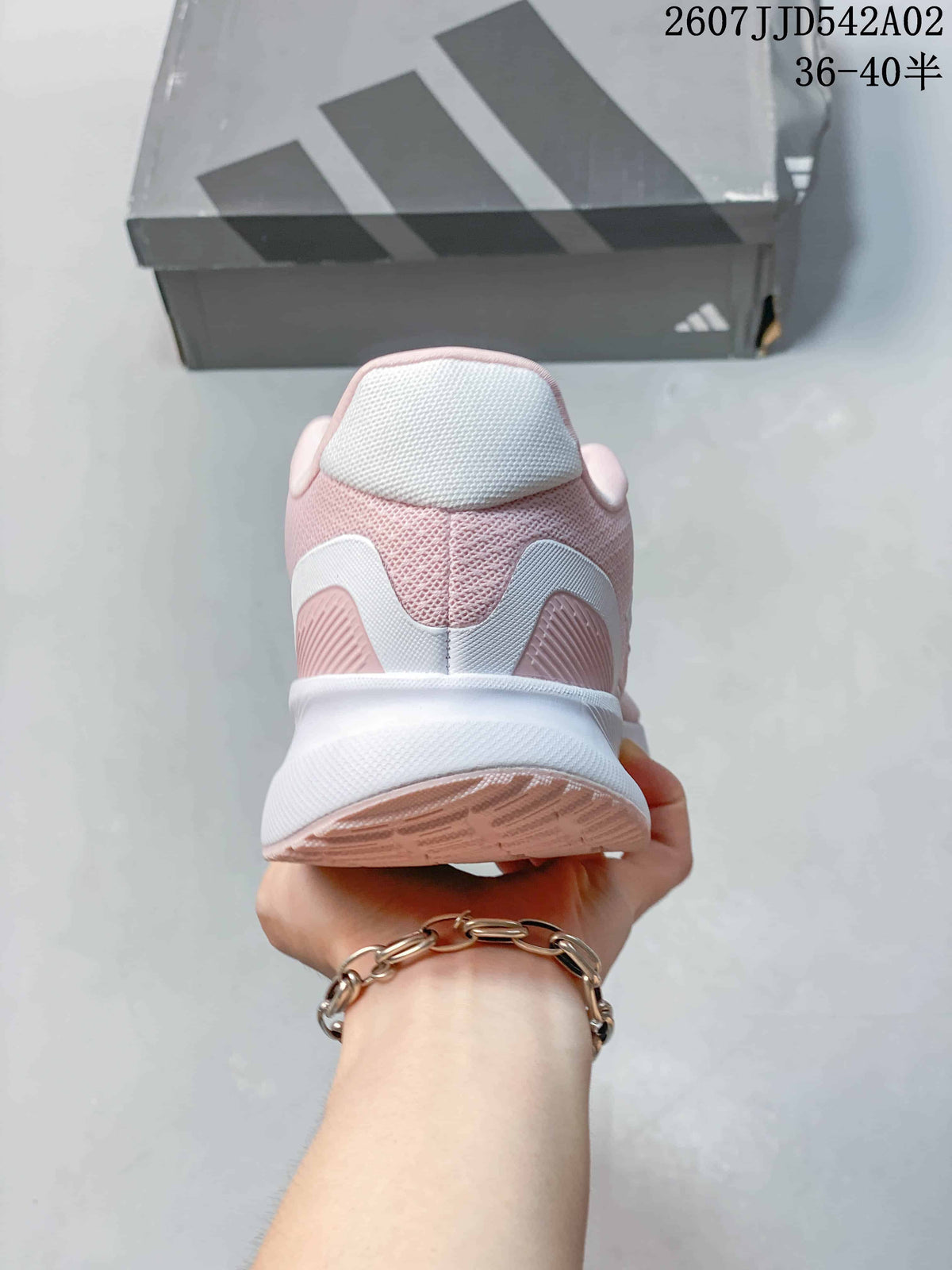 Rear view of the pink running shoe with a white midsole and heel details.