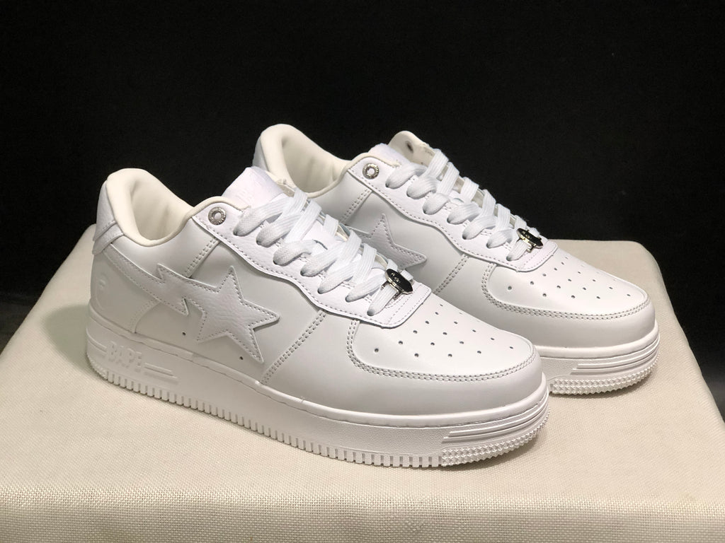Angled side view of the white sneakers with tonal star panels and branded sidewalls.