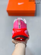 Rear view of the pink sneaker showing the padded heel, red heel structure and textured upper.