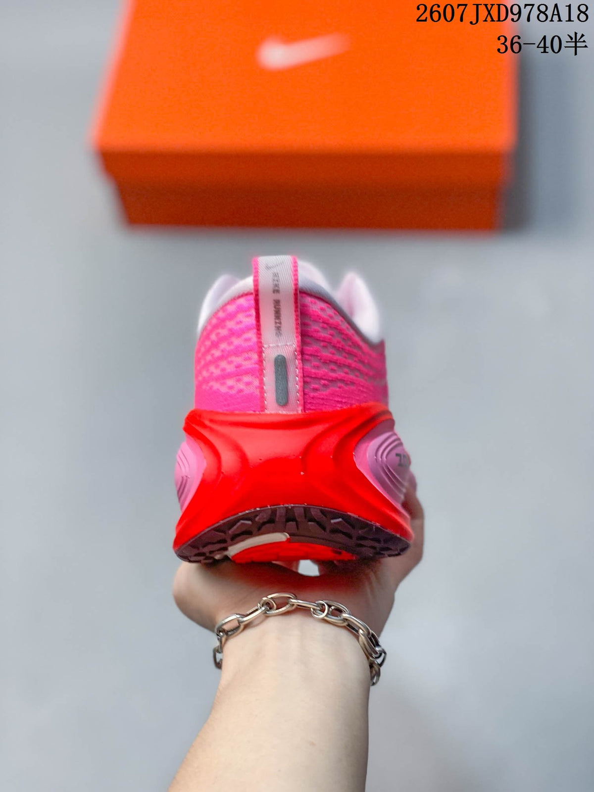 Rear view of the pink sneaker showing the padded heel, red heel structure and textured upper.