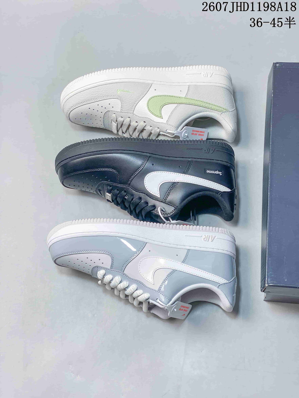 Top-down view showing the white/light green, black/white, and light blue/white sneaker colorways together beside a shoebox.