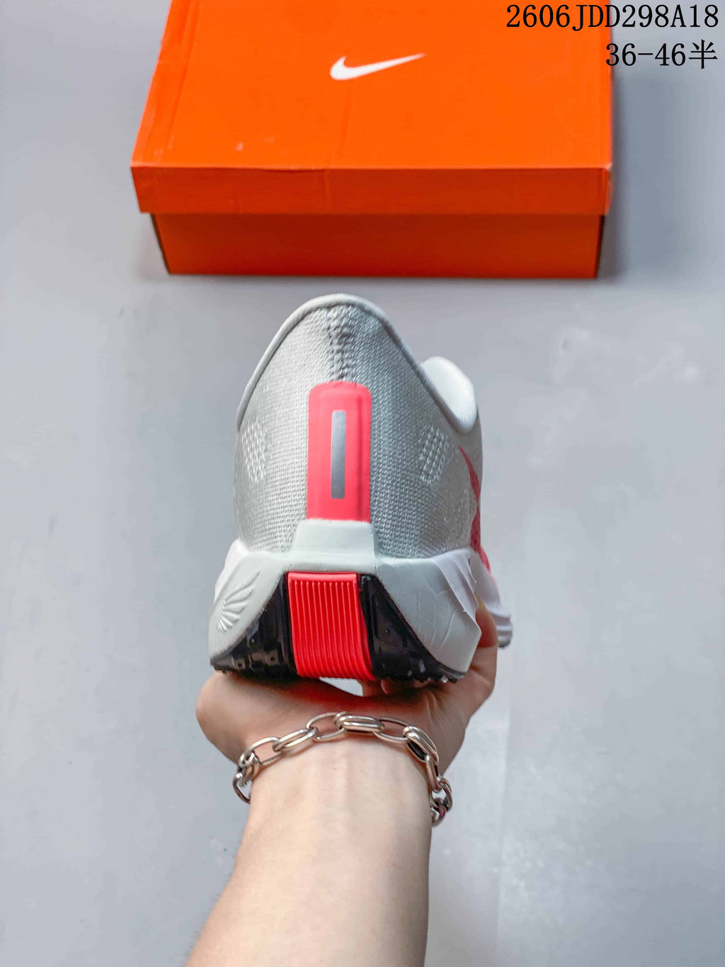 Rear view of the sneaker showing the grey heel, red vertical accent, white midsole, and black outsole.