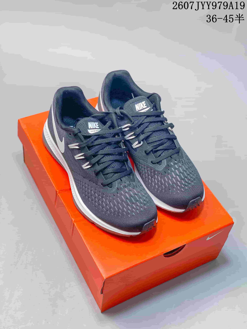 Front three-quarter view of a pair of dark gray Nike Air Zoom Winflo 5 shoes on an orange shoebox.