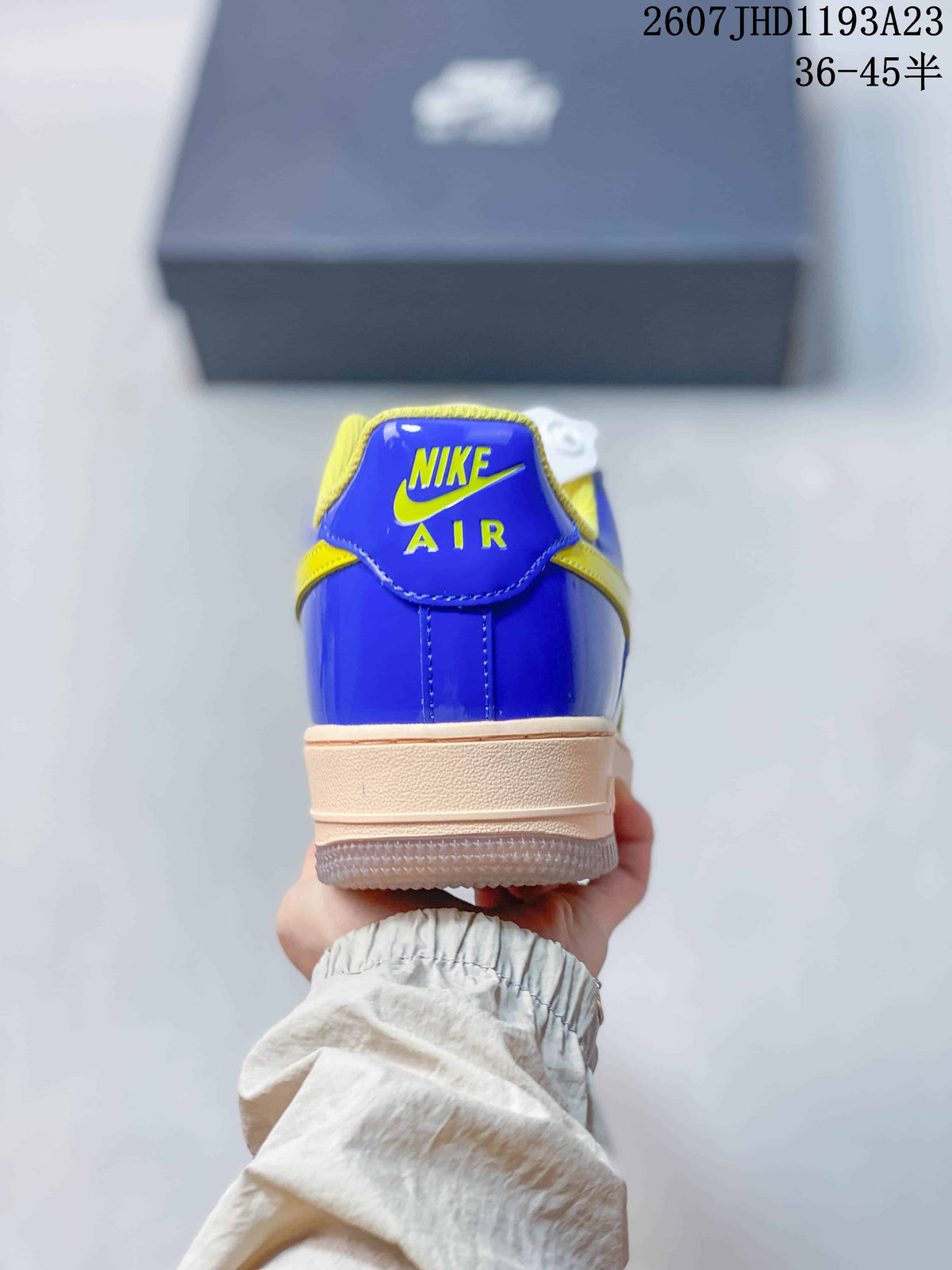 Rear view of the sneaker showing the blue heel panel, yellow Nike Air branding, and light-colored midsole.