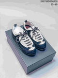Pair of black and white low-top sneakers displayed on a box, with patterned laces and visible side branding.