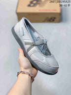 Close-up side view of a gray New Balance low-top sneaker showing contrast panels, laces, and dark outsole.