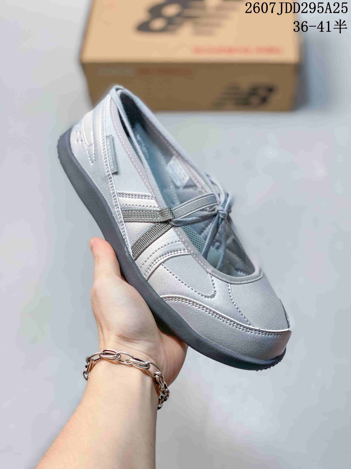 Close-up side view of a gray New Balance low-top sneaker showing contrast panels, laces, and dark outsole.