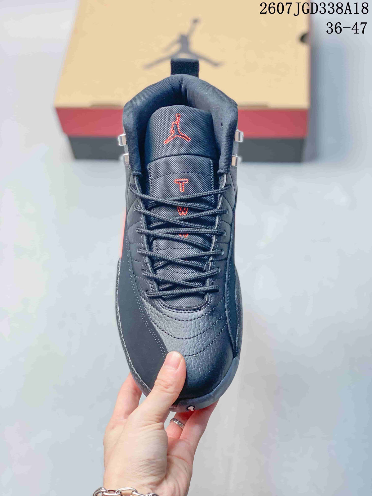 Front view of the sneaker showing the padded tongue, red Jumpman-style logo, laces, and rounded toe.
