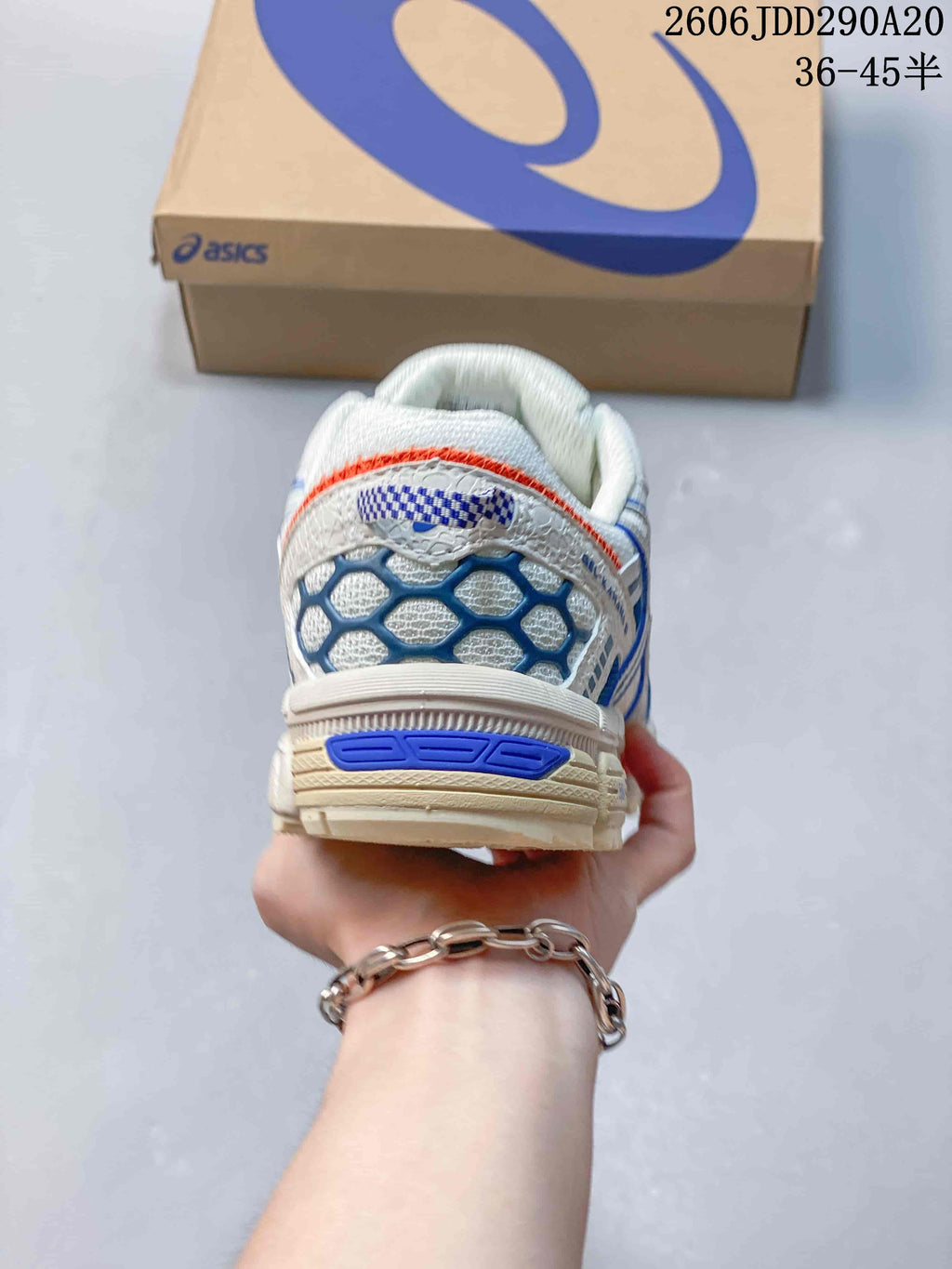 Rear view of the sneaker showing the padded heel area, blue detailing, and orange accent line.