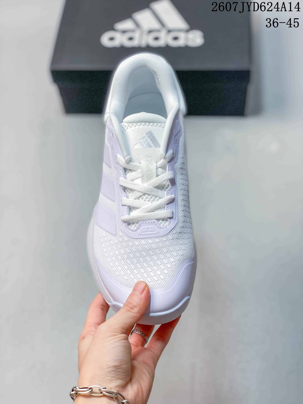 Top view of a white lace-up training shoe with a textured mesh toe and adidas tongue branding.