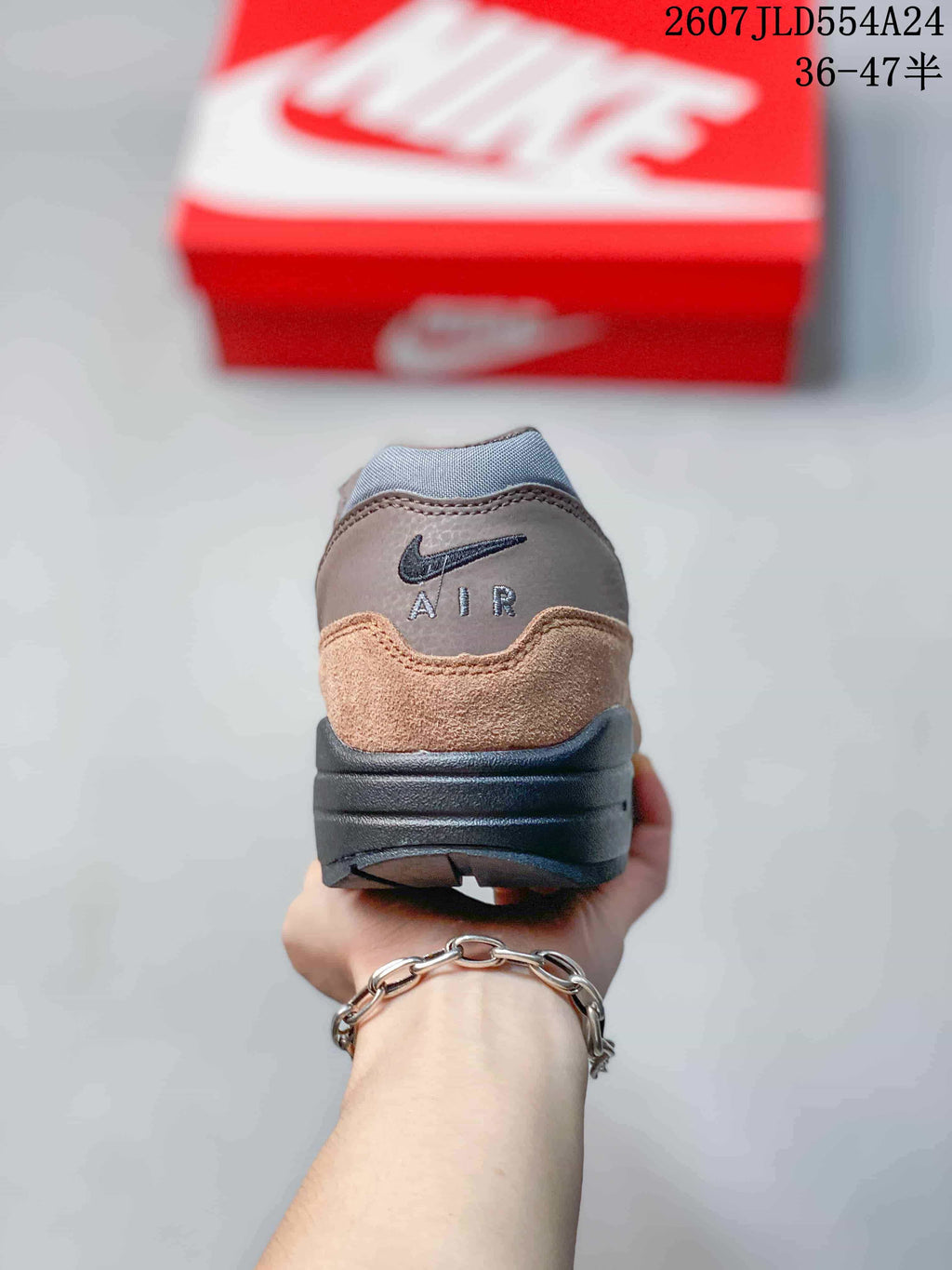 Rear view of the brown and grey Nike Air Max 1 sneaker with Air branding on the heel.