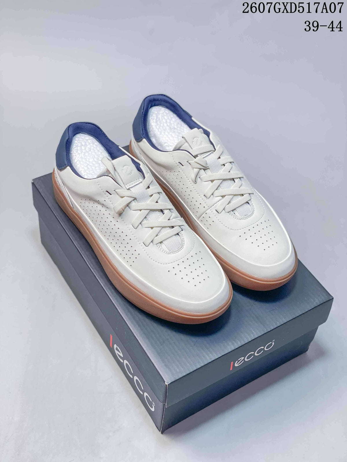 Pair of white ECCO low-top sneakers with navy collars and gum-colored soles displayed on a branded shoebox; style code 2607GXD517A07 and size range 39-44 are visible.