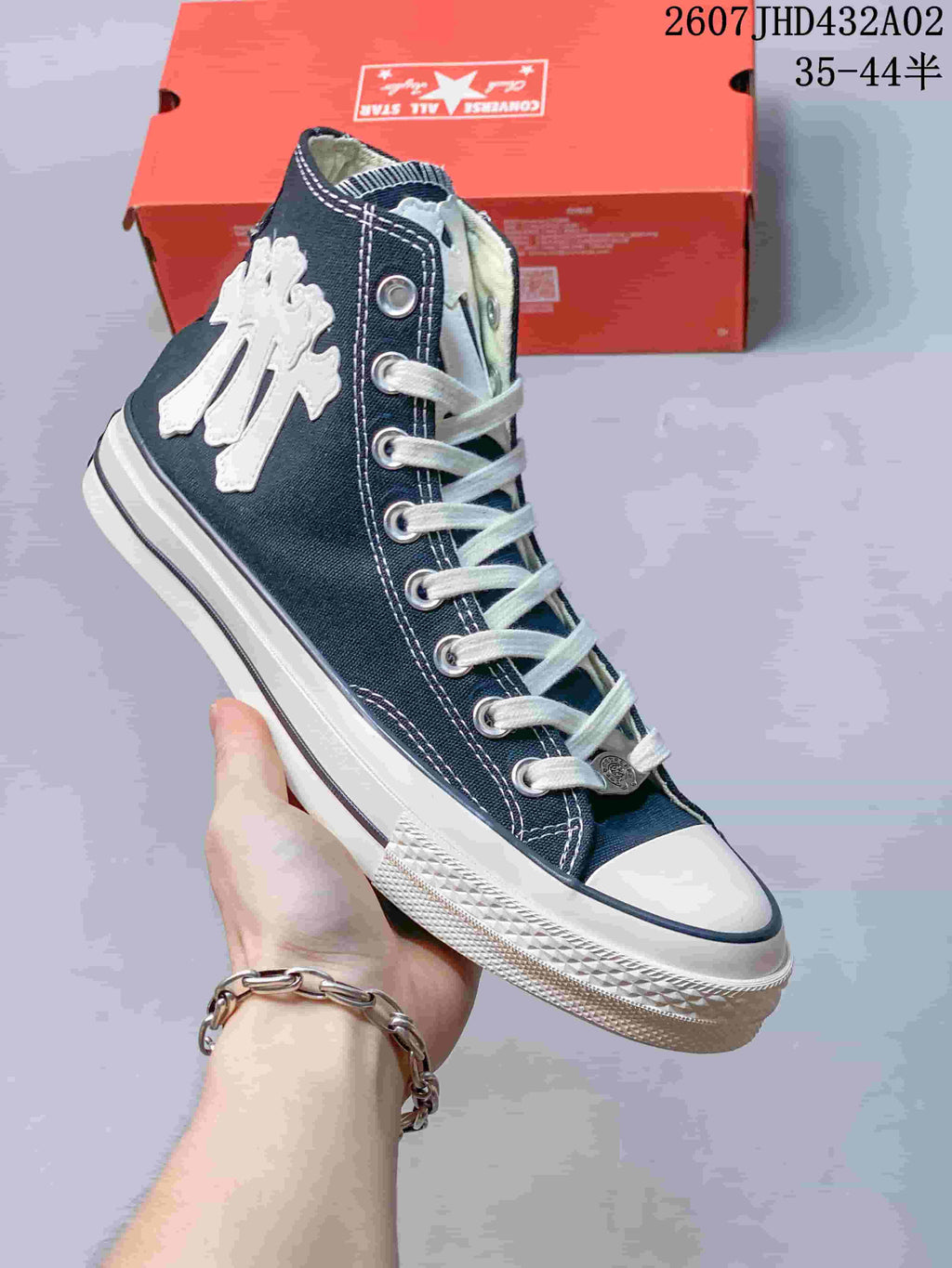 Angled view of a navy high-top sneaker with a large white side patch