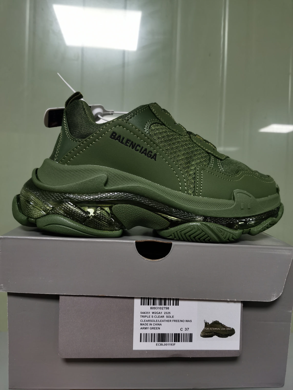 Army green Balenciaga Triple S sneaker displayed on its box, with the box label showing style code 544351 W2GA1 2325, Triple S Clear Sole and size C 37.