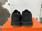 Rear view of black Nike basketball shoes with gold-toned outsole details.