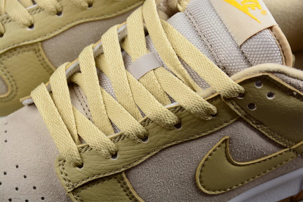 Close-up of the sneaker's sesame laces, layered side panels, and embroidered side Swoosh