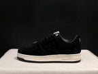 Side profile of a black low-top sneaker with a tonal star panel, white midsole and black outsole.