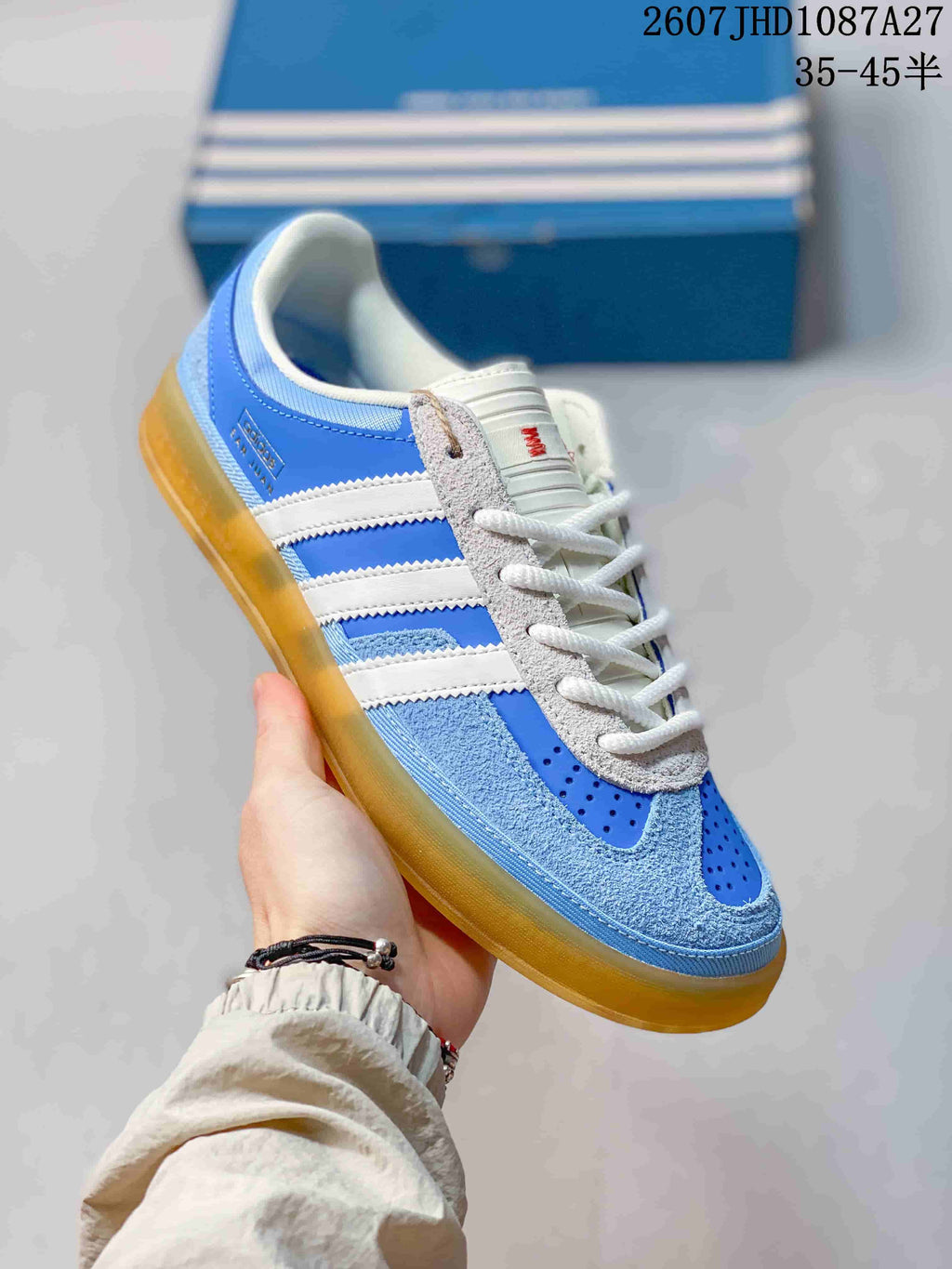 Angled side view showing the blue and white upper, three stripes, laces, and translucent gum-colored sole.