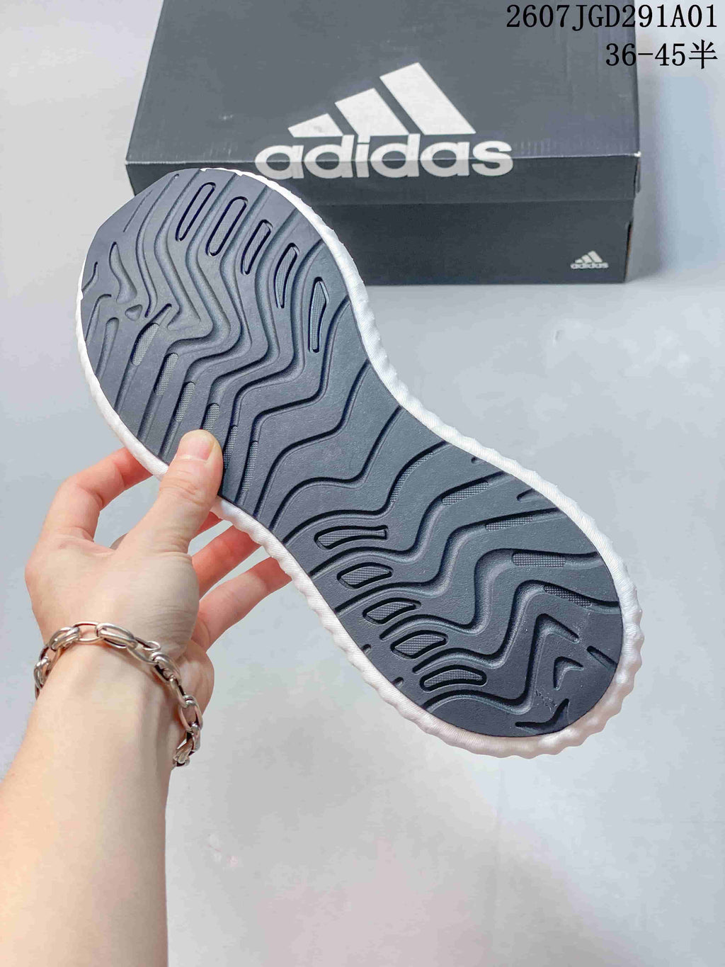 Close-up of the dark patterned outsole on a white adidas sneaker