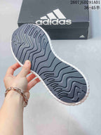 Close-up of the dark patterned outsole on a white adidas sneaker