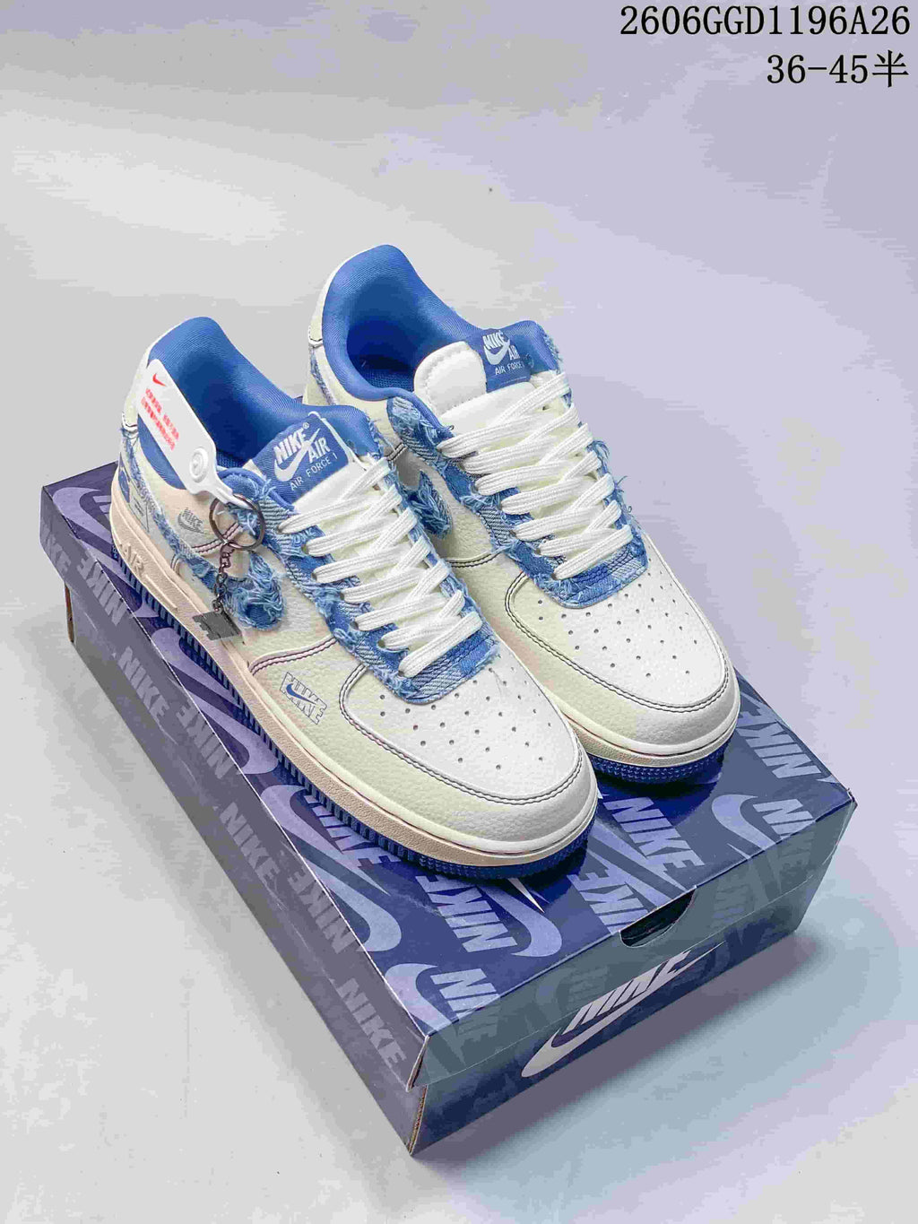 Pair of white low-top sneakers with blue denim-look panels, frayed trim, and blue collars.