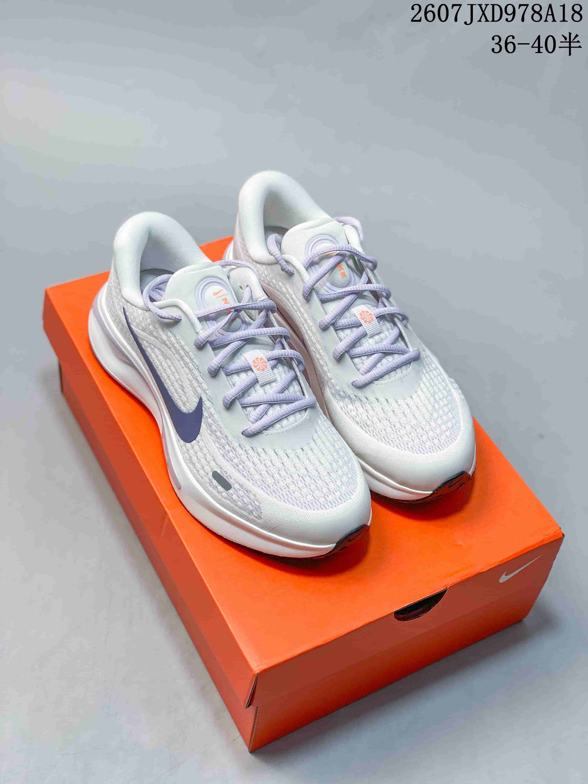 Pair of white and lavender Nike Journey Run sneakers displayed on an orange shoebox; image text shows code 2607JXD978A18 and size range 36–40.5.