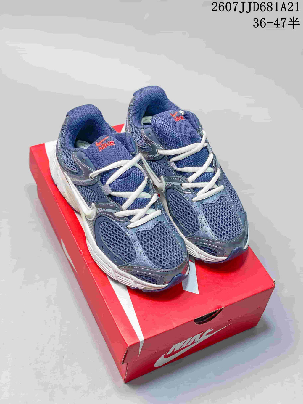 Pair of blue and white Nike V5 RNR sneakers displayed on a red shoebox, with the style code and size range visible above.