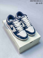 Pair of navy and white low-top sneakers displayed on a shoe box, with the style code and advertised size range visible at the top.