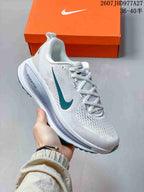 Angled side view of the white sneaker showing the teal Swoosh, mesh-textured upper, layered sole and teal outsole accents; overlay text shows style code 2607JHD977A27 and sizes 36–40.5.