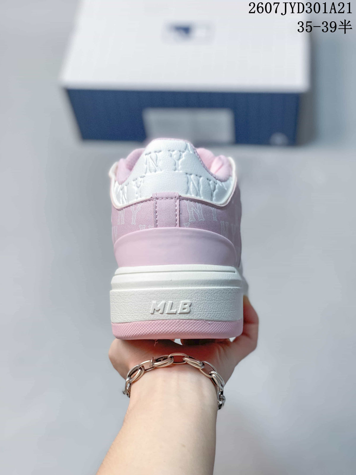 Rear view of a pink and white sneaker with MLB branding on the heel and a layered sole.