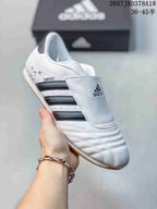 Close side view of a white adidas sneaker showing the tongue cover, dark stripes and SMIL-LS marking.