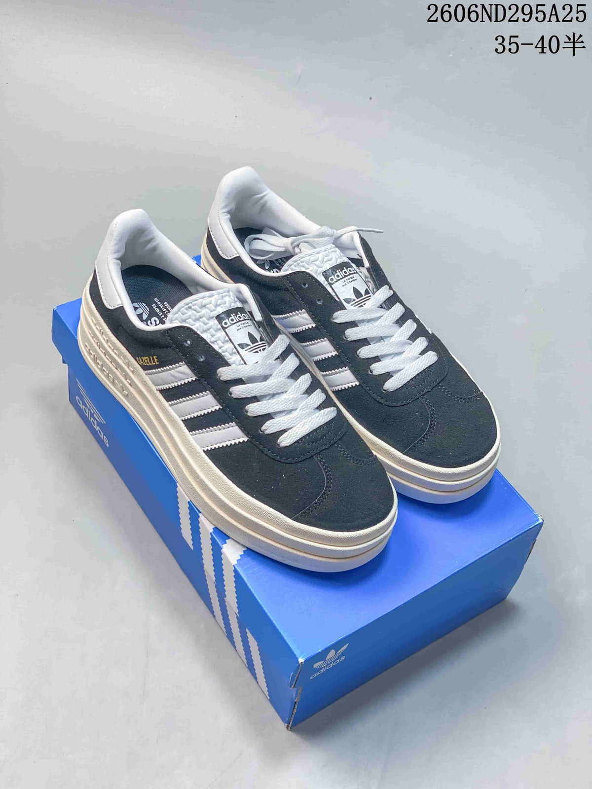 Pair of black and white Adidas Gazelle Bold sneakers displayed on a blue shoebox, showing the platform soles and lace-up design.