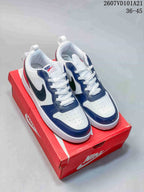 Pair of Nike Court Borough Mid BG sneakers in white, navy and red, shown on a red shoe box.