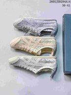 Top-down display of three Onitsuka Tiger sneaker colorways in lavender, beige, and pale gray, showing the low-top profile and textured panel construction.