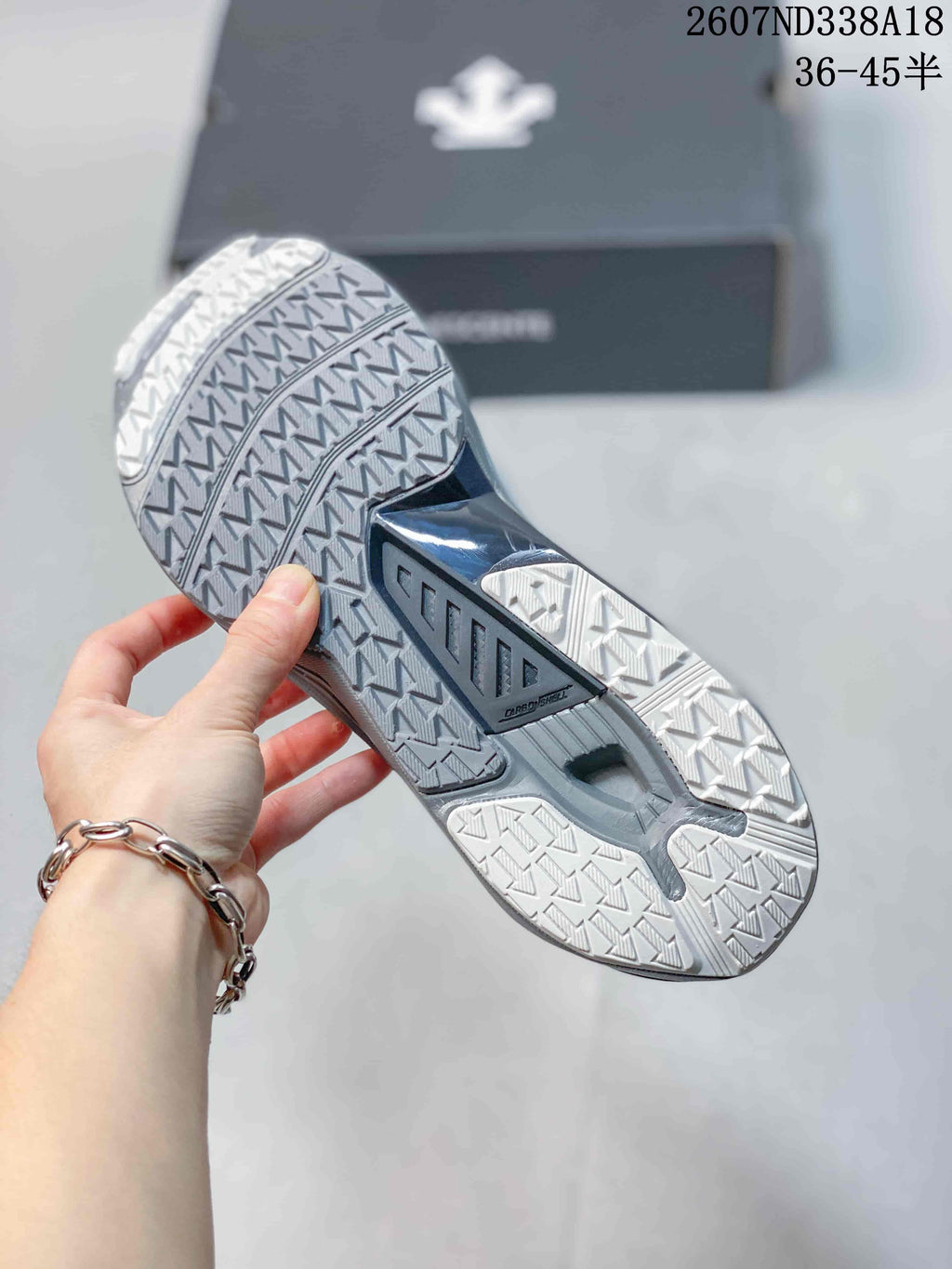 Close-up of the sneaker outsole showing segmented tread patterns and a central dark support section.