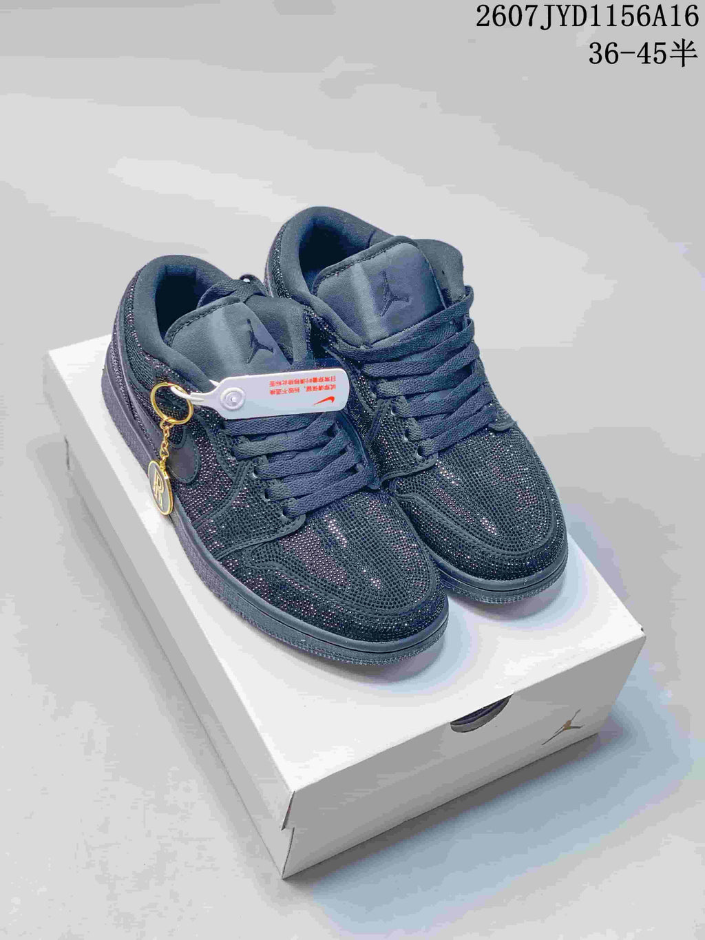 Pair of black Jordan Air Jordan 1 sneakers with reflective embellished uppers, displayed on a shoebox.