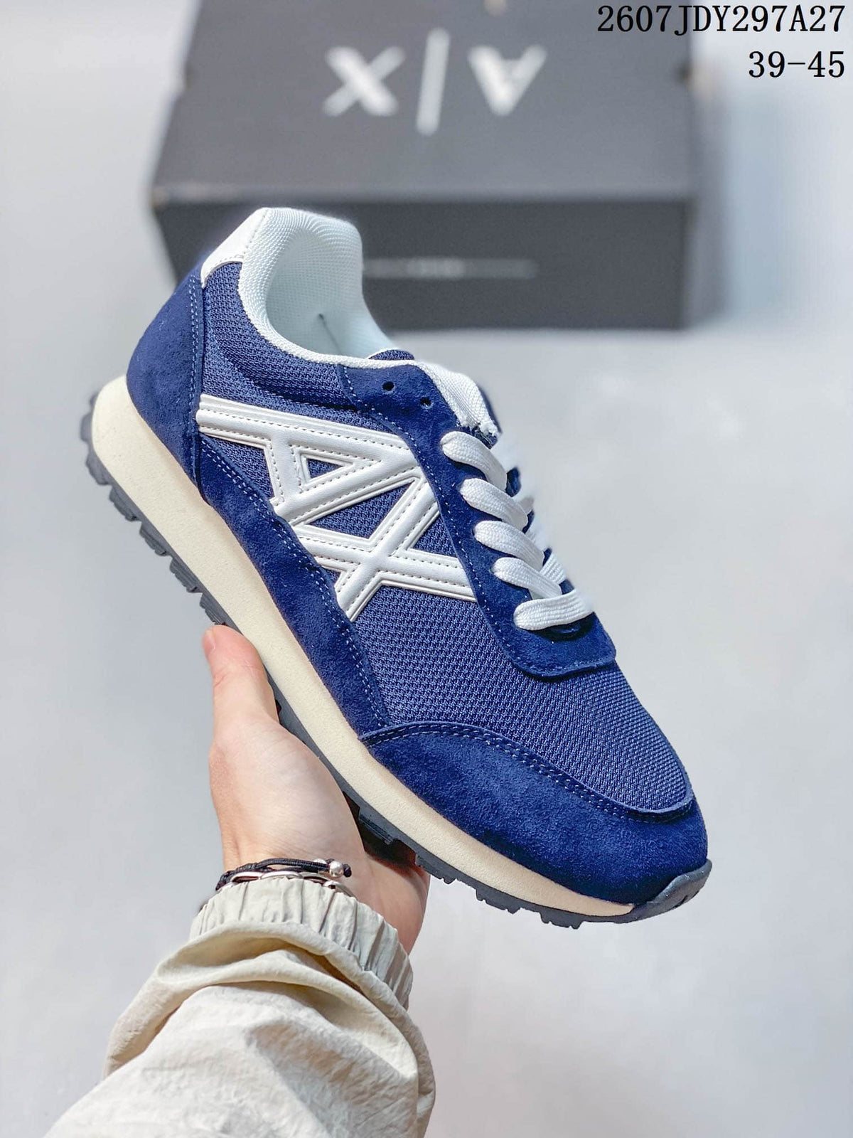 Blue low-top sneaker with white laces, a cream-colored midsole, and a contrasting side logo.