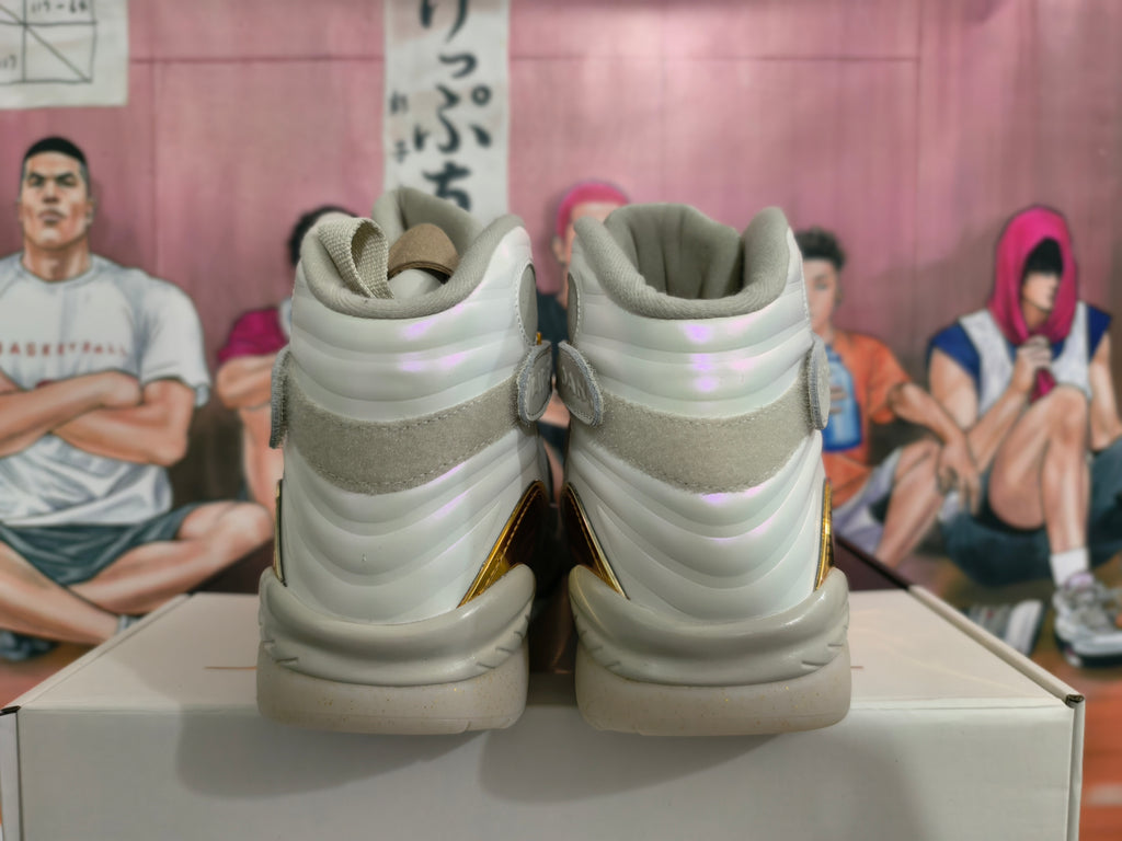 Rear view of light gray and cream high-top Jordan sneakers with gold accents