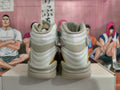 Rear view of light gray and cream high-top Jordan sneakers with gold accents