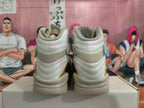 Rear view of light gray and cream high-top Jordan sneakers with gold accents