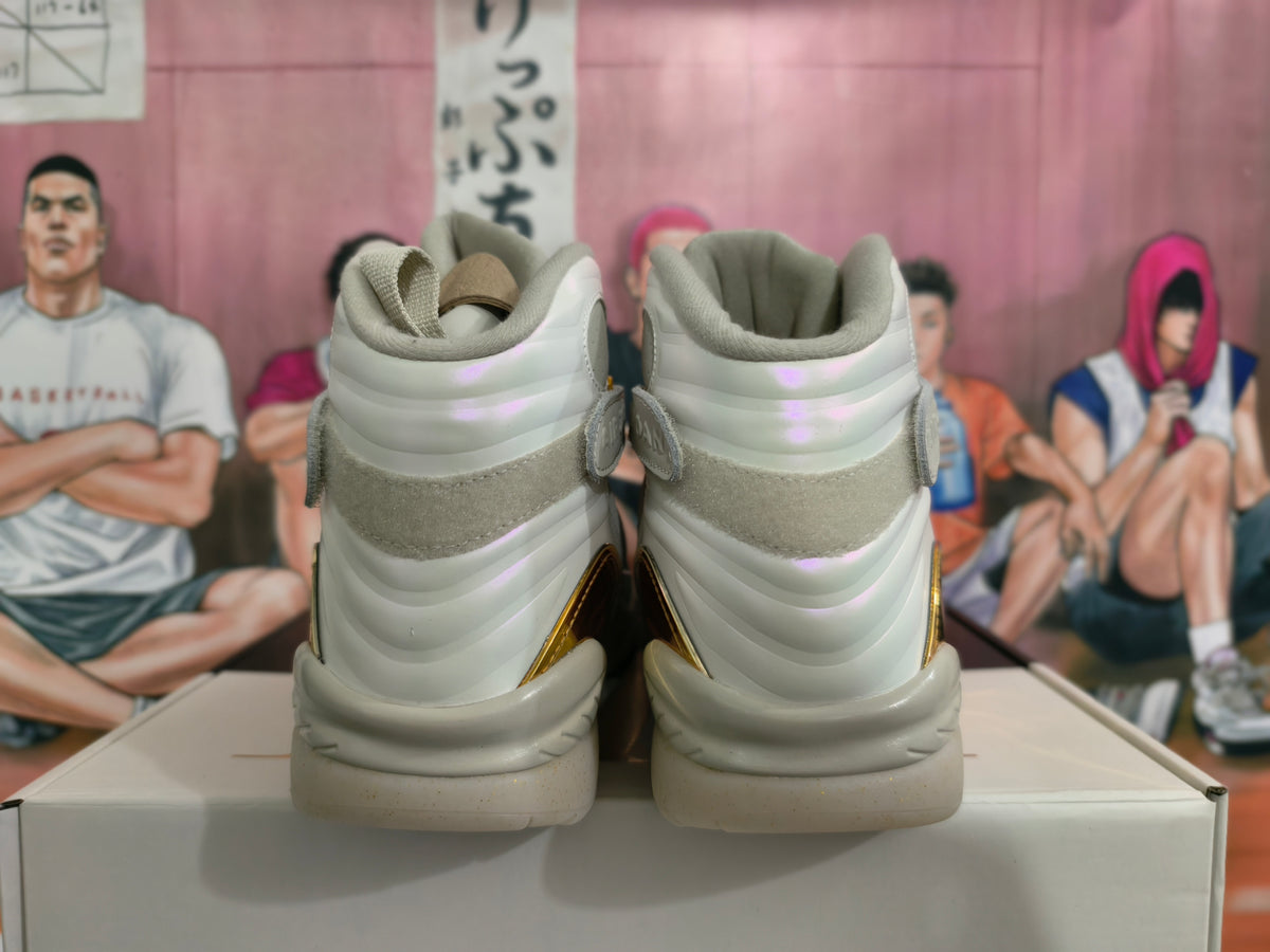 Rear view of light gray and cream high-top Jordan sneakers with gold accents
