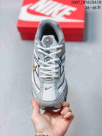 Top view of the grey and white lace-up sneaker with orange and black branding details.