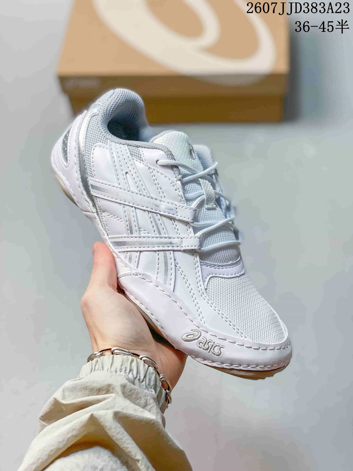 Angled front-side view of the white ASICS sneaker showing the layered upper, mesh toe panel and ASICS branding.